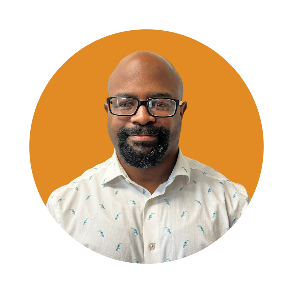 Mr. Greg, Senior Registered Behavior Technician at Therapy Smarts, smiling in a professional setting with an orange background.