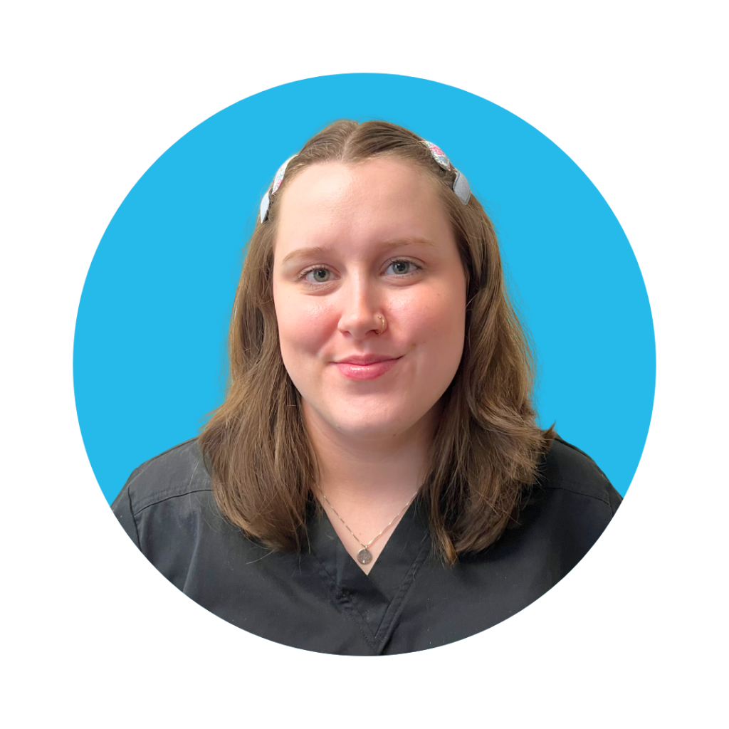 Behavior Technician Ms. Hailey smiling in a black uniform against a bright blue background, representing the ABA team at Therapy Smarts.